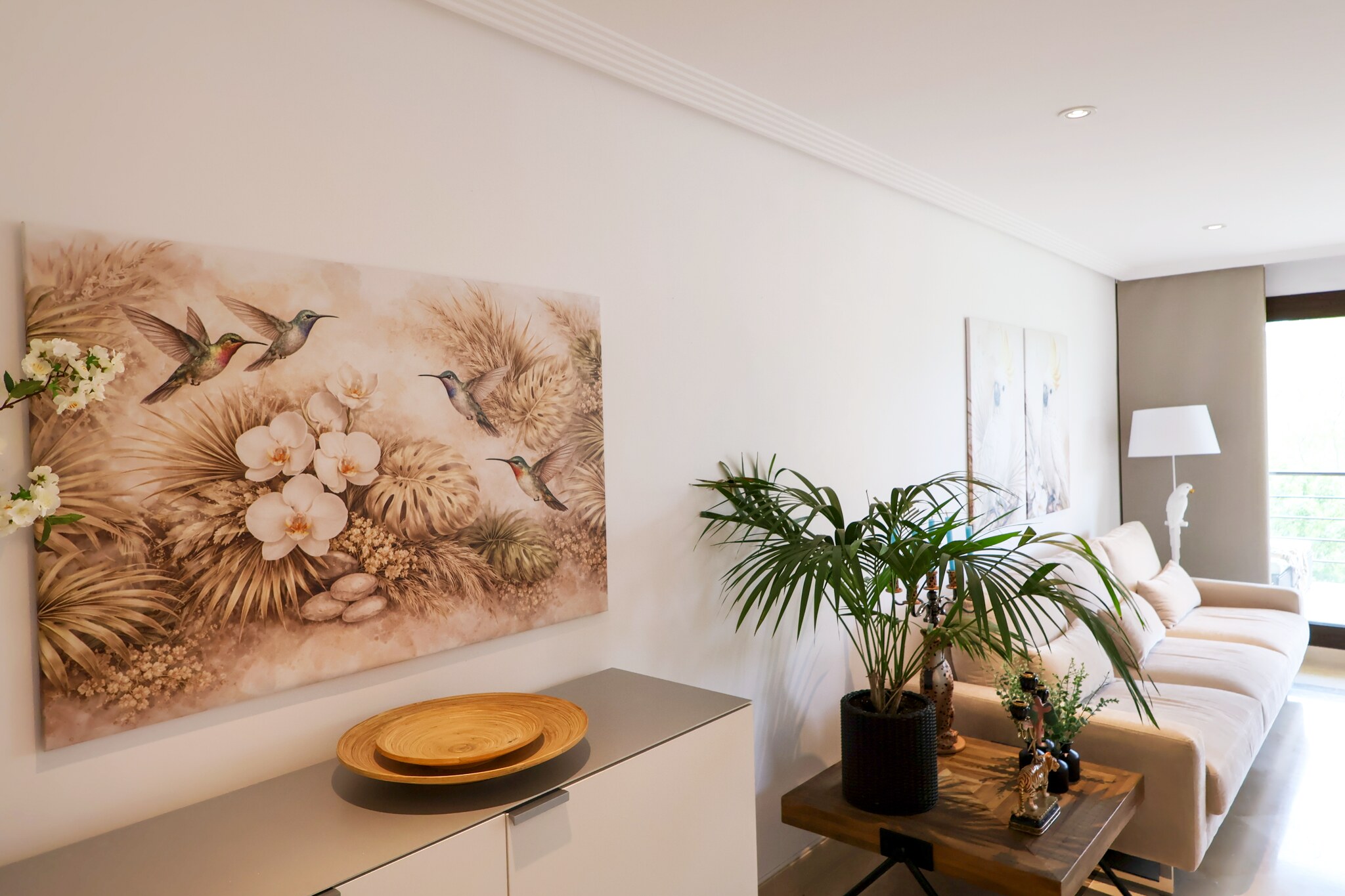 Wide view of a Marbella apartment styled for sale with bespoke artwork and plants